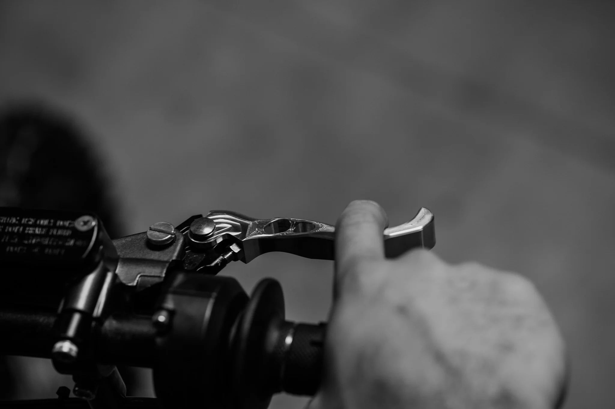 Close-up of a hand operating a Pirckly Motosports brake lever.